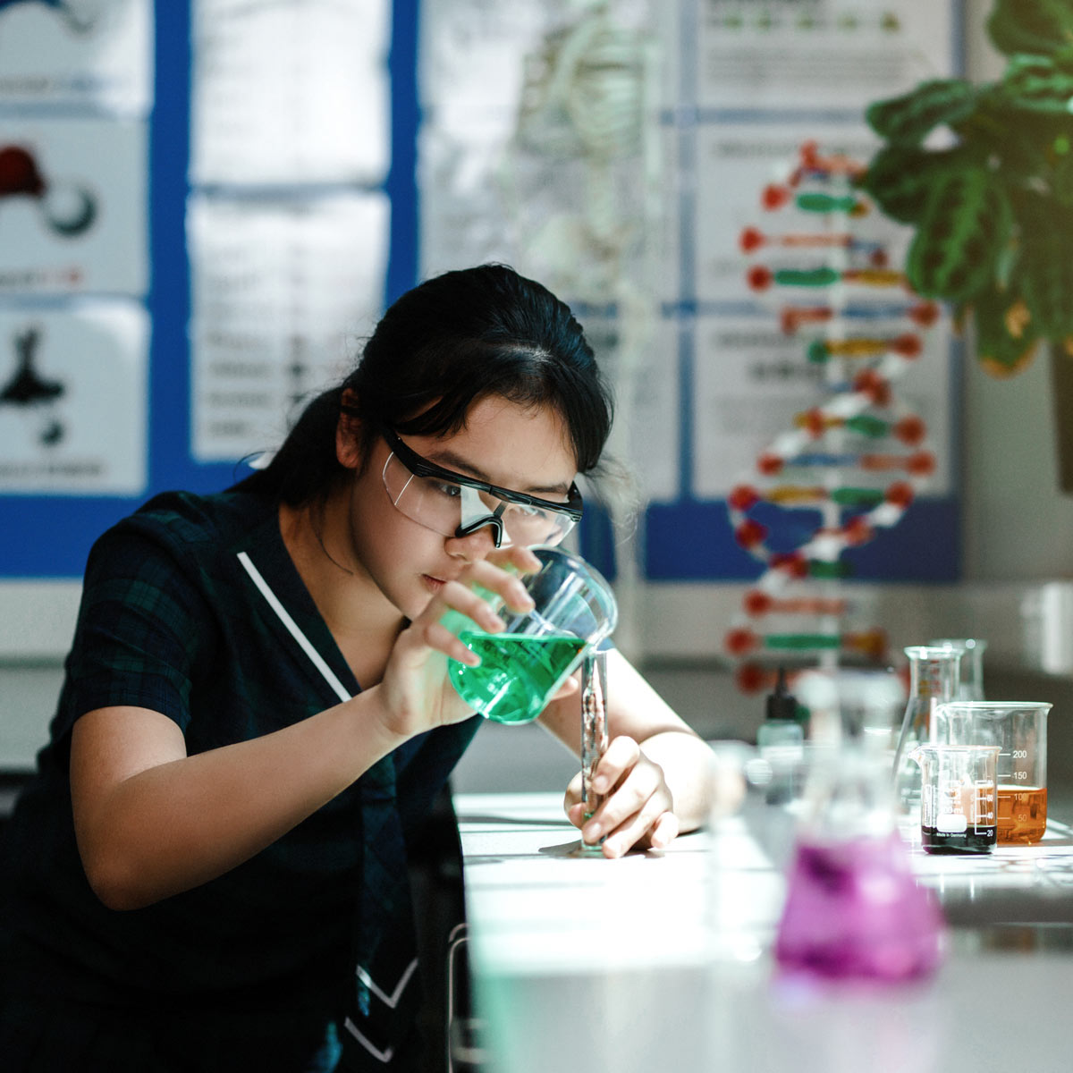 Senior girl using beaker in science lab